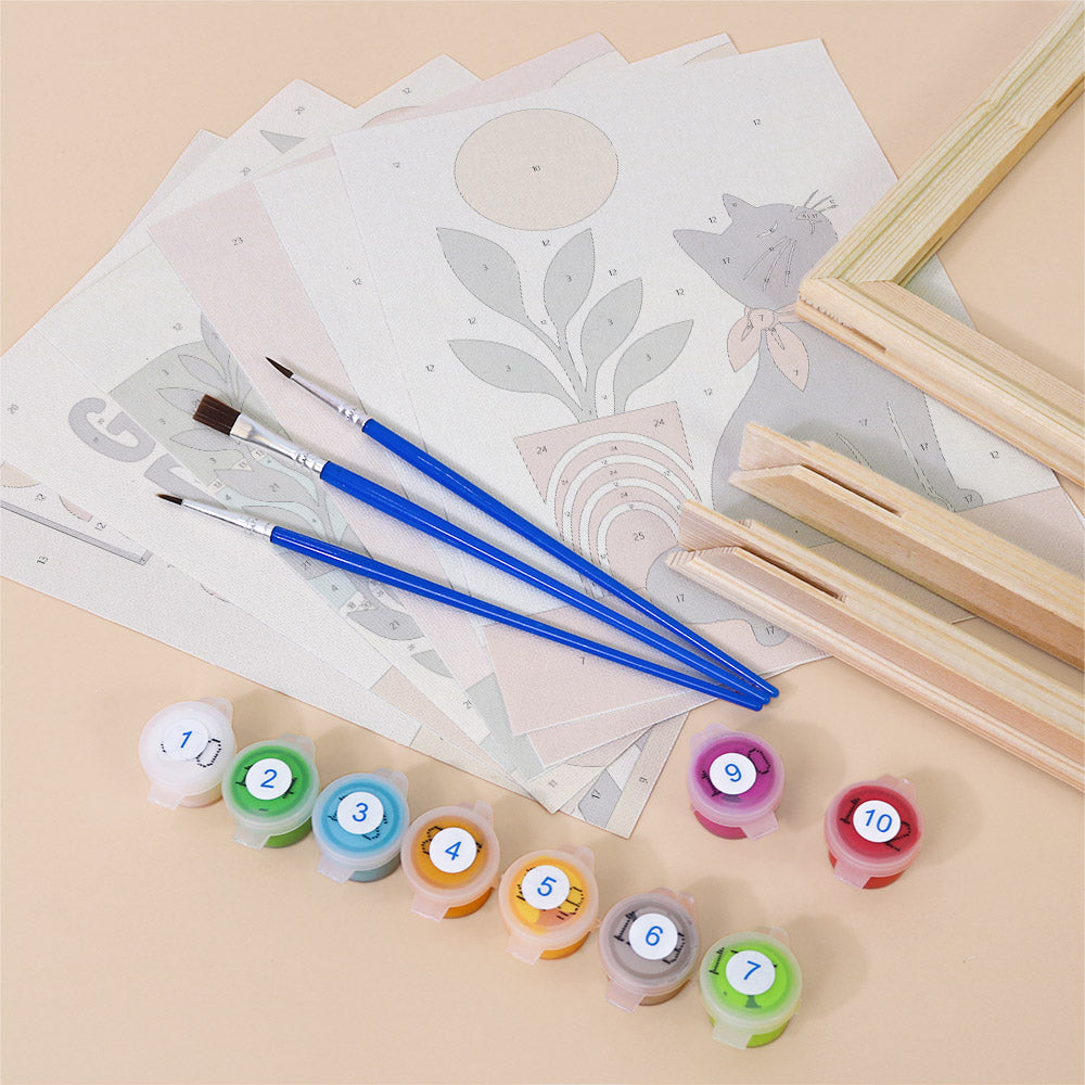 various art supplies, including paintbrushes, paint tubes, and a sketchbook, arranged on a table.
