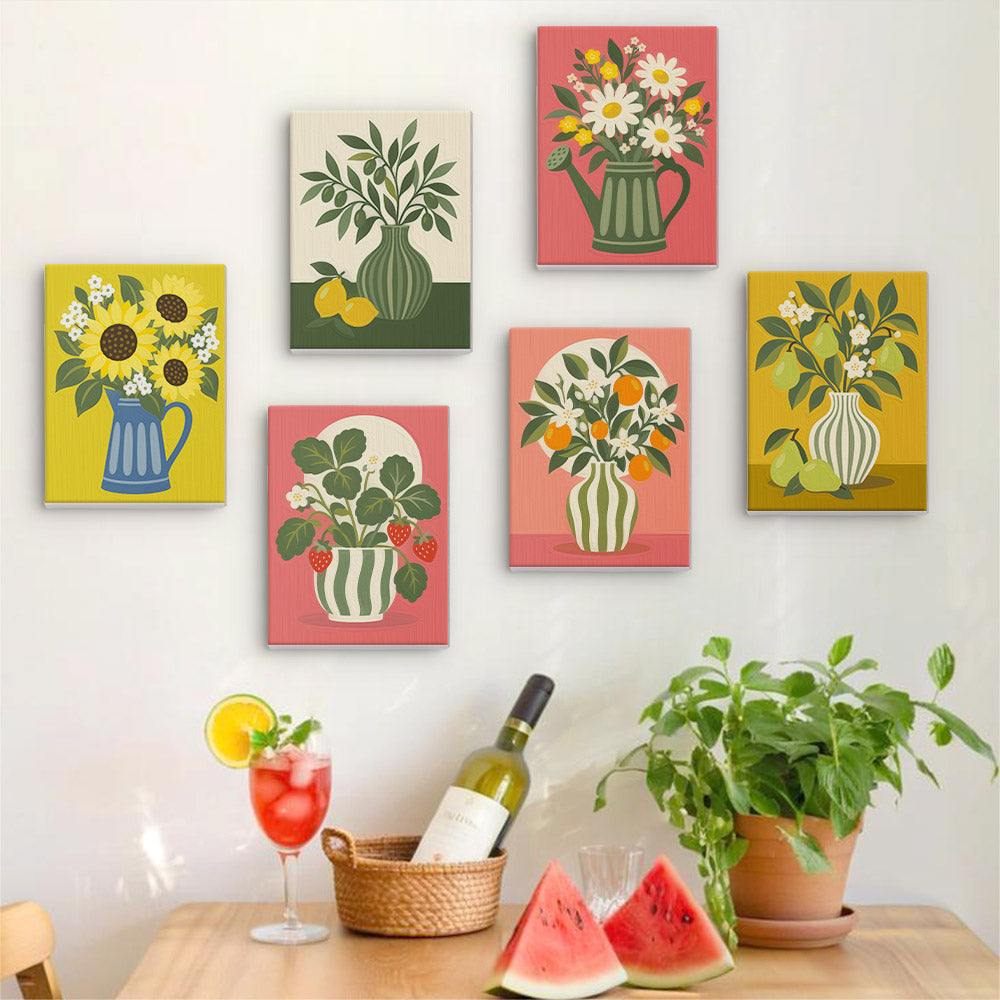 a wall adorned with six vibrant paintings of flowers and plants, each with a unique color scheme and style. In front of the wall, there is a table with a wine bottle, a glass filled with a red drink, and a basket of fresh fruit, including watermelon slices and lemons.