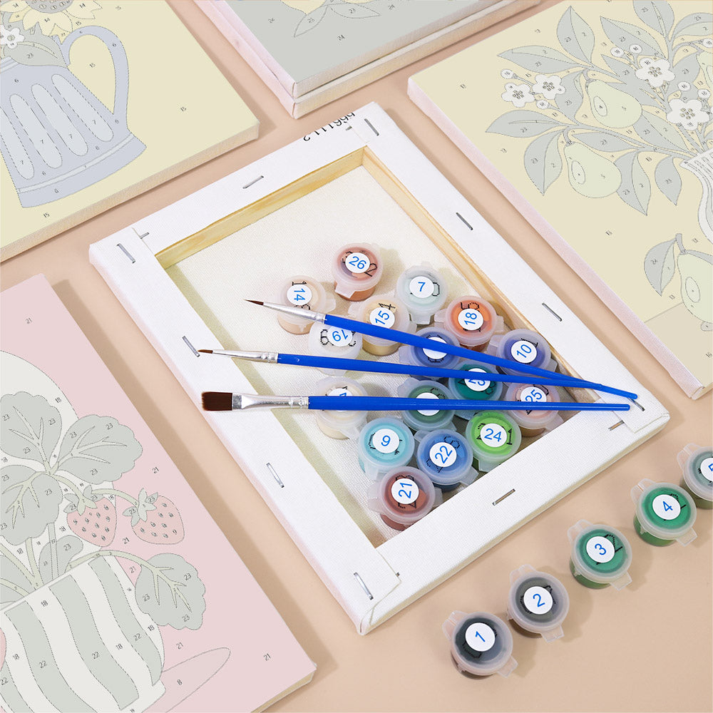 a painting kit with a canvas, paintbrushes, and various paint colors arranged on a table.