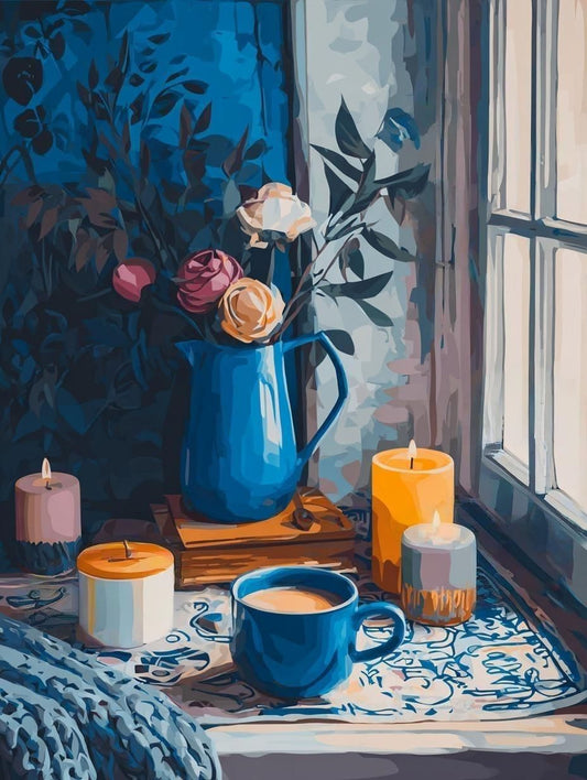 A cozy scene with a blue vase holding flowers, a blue mug, and candles on a table near a window.