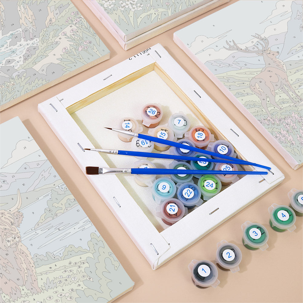 a painting kit with a canvas, paintbrushes, and multiple paint tubes with numbers on them, suggesting it is a kit for painting landscapes.