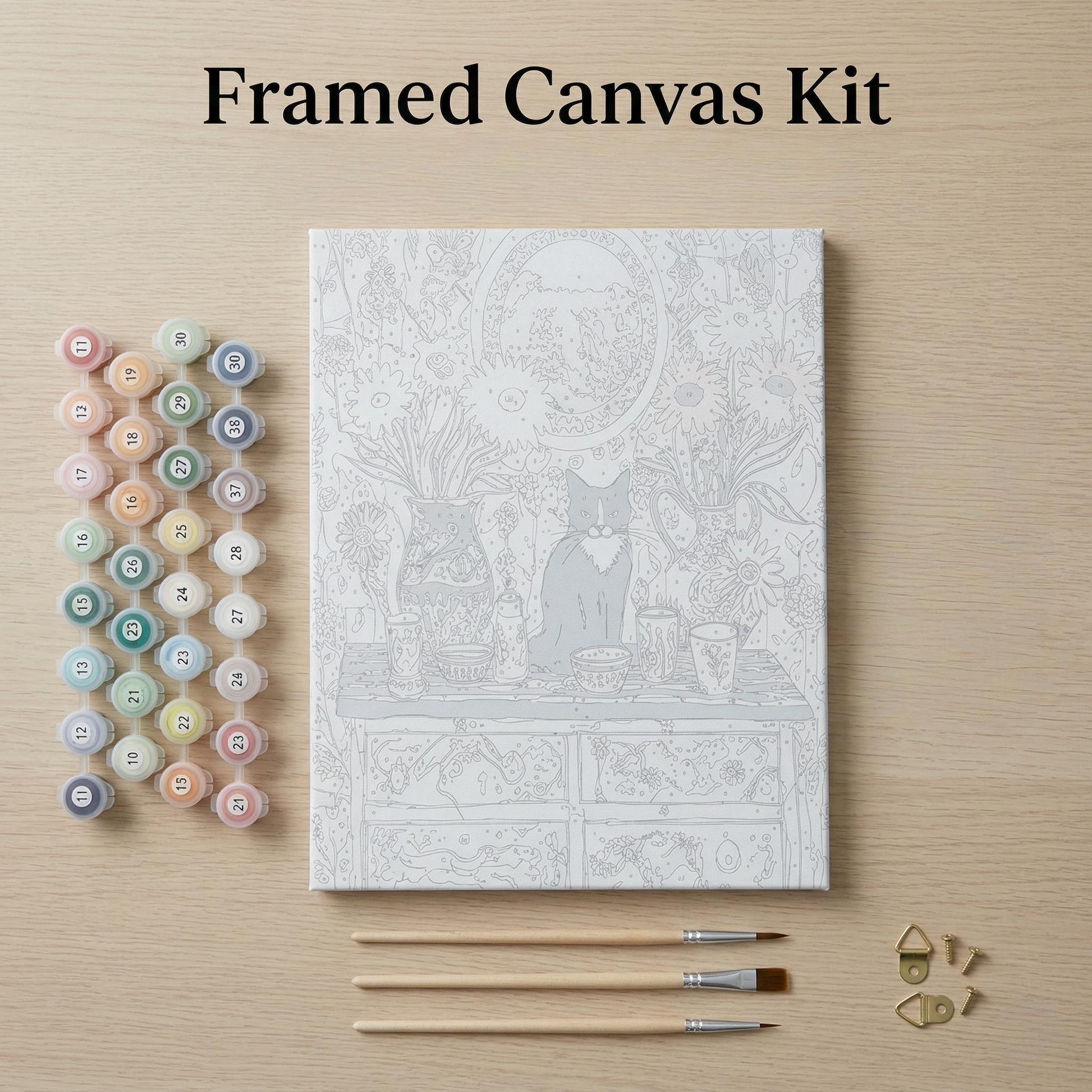 a framed canvas kit with a detailed illustration of a cat sitting on a table, surrounded by various art supplies such as paintbrushes and paint tubes.