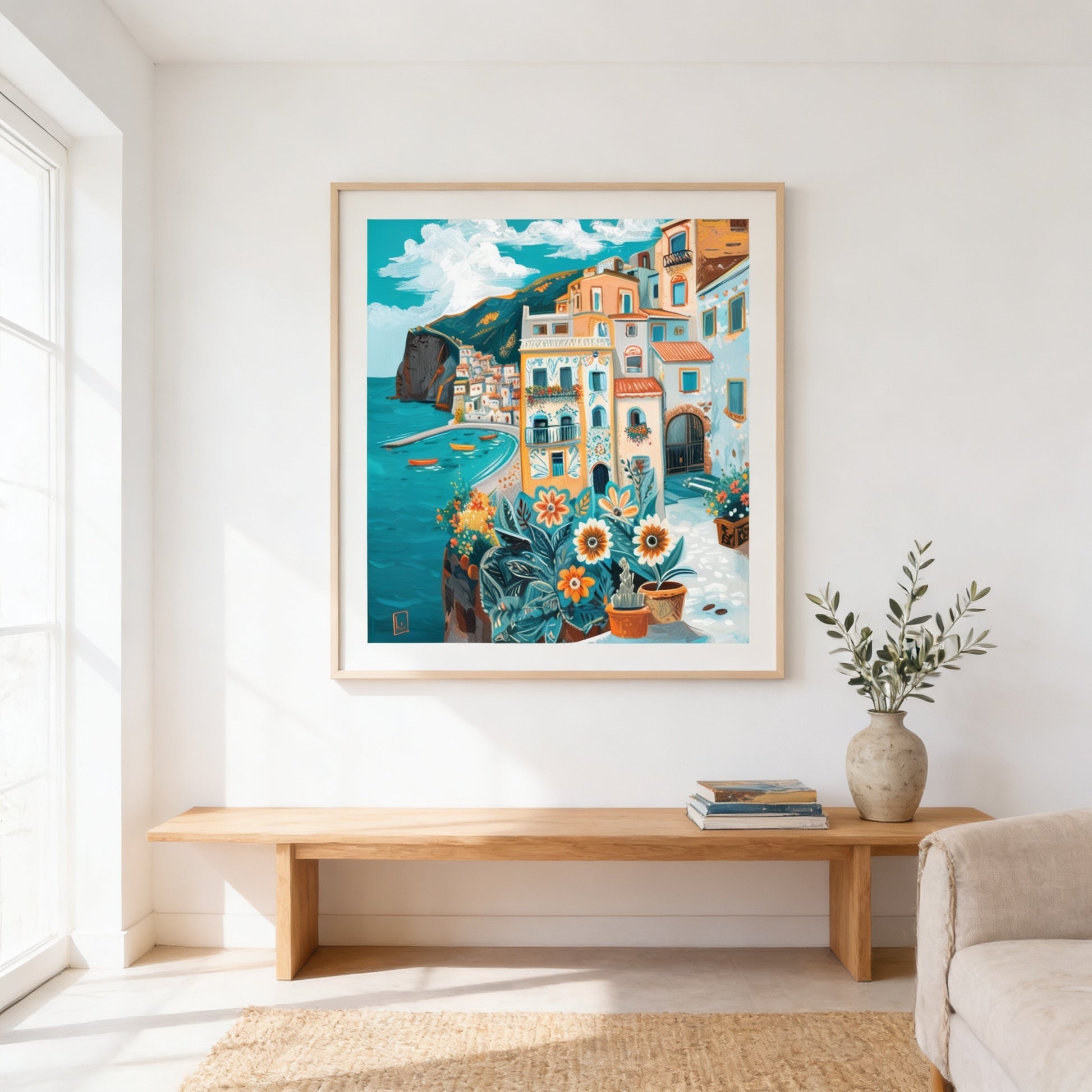 a large framed painting of a coastal town with colorful buildings, a blue sea, and a boat in the distance. The painting is hung on a white wall above a wooden bench, which is situated in a bright, airy room with a window.