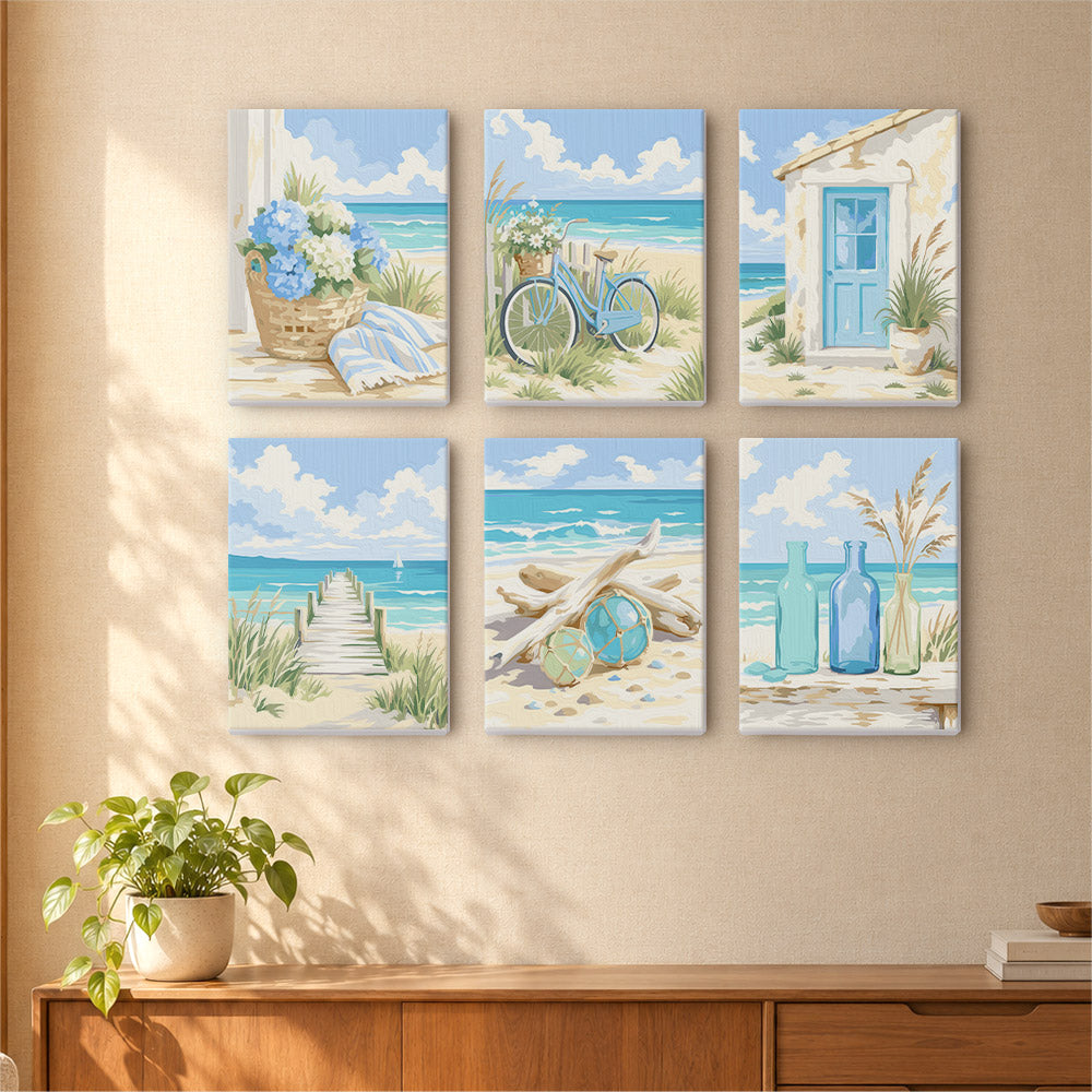 A wall with six square paintings depicting various beach scenes, including a bicycle, a basket of flowers, a house, a path leading to the beach, driftwood, and a bottle of blue bottles.