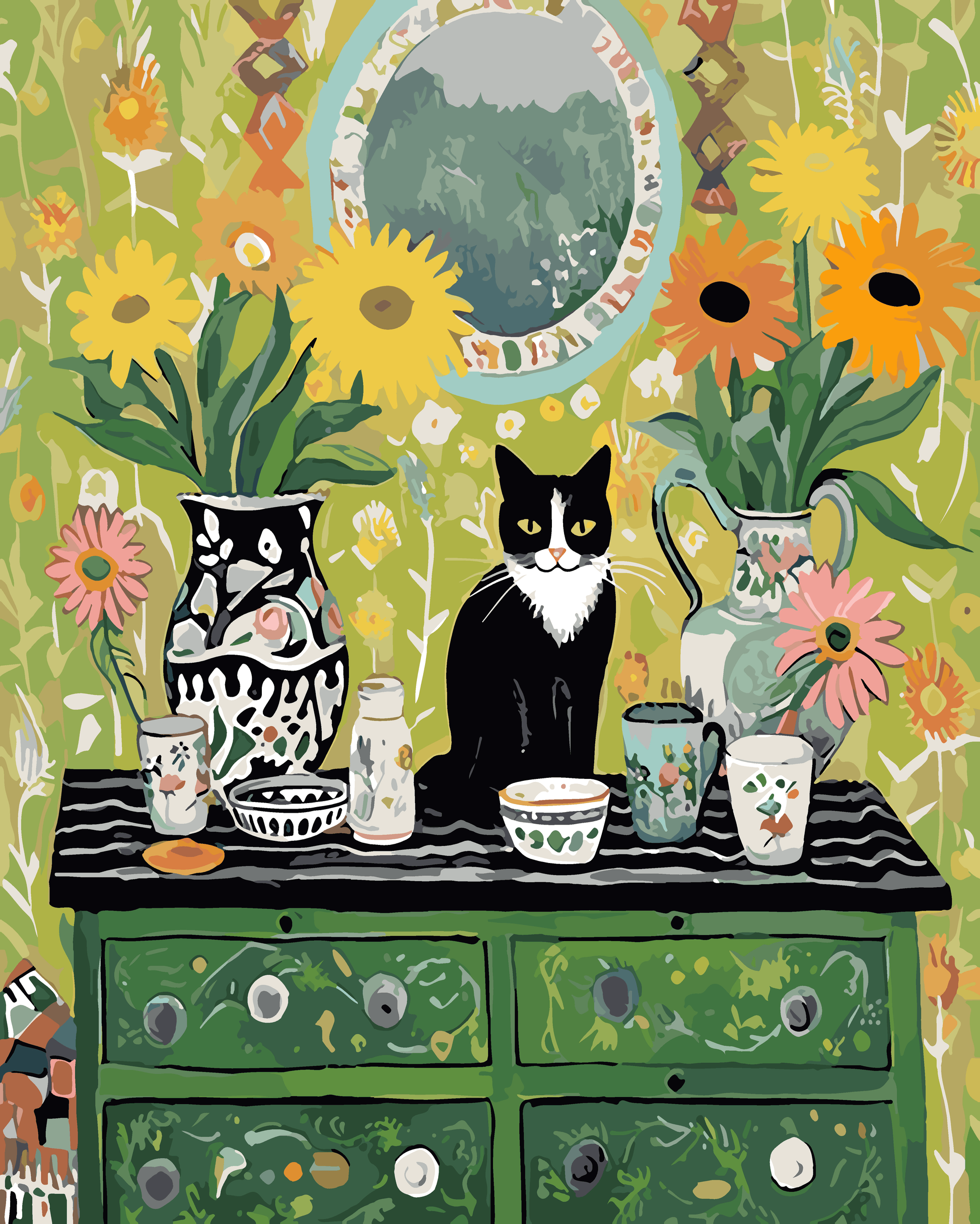 A black and white cat sits on a table surrounded by colorful vases, cups, and bowls, with a mirror and flowers in the background.