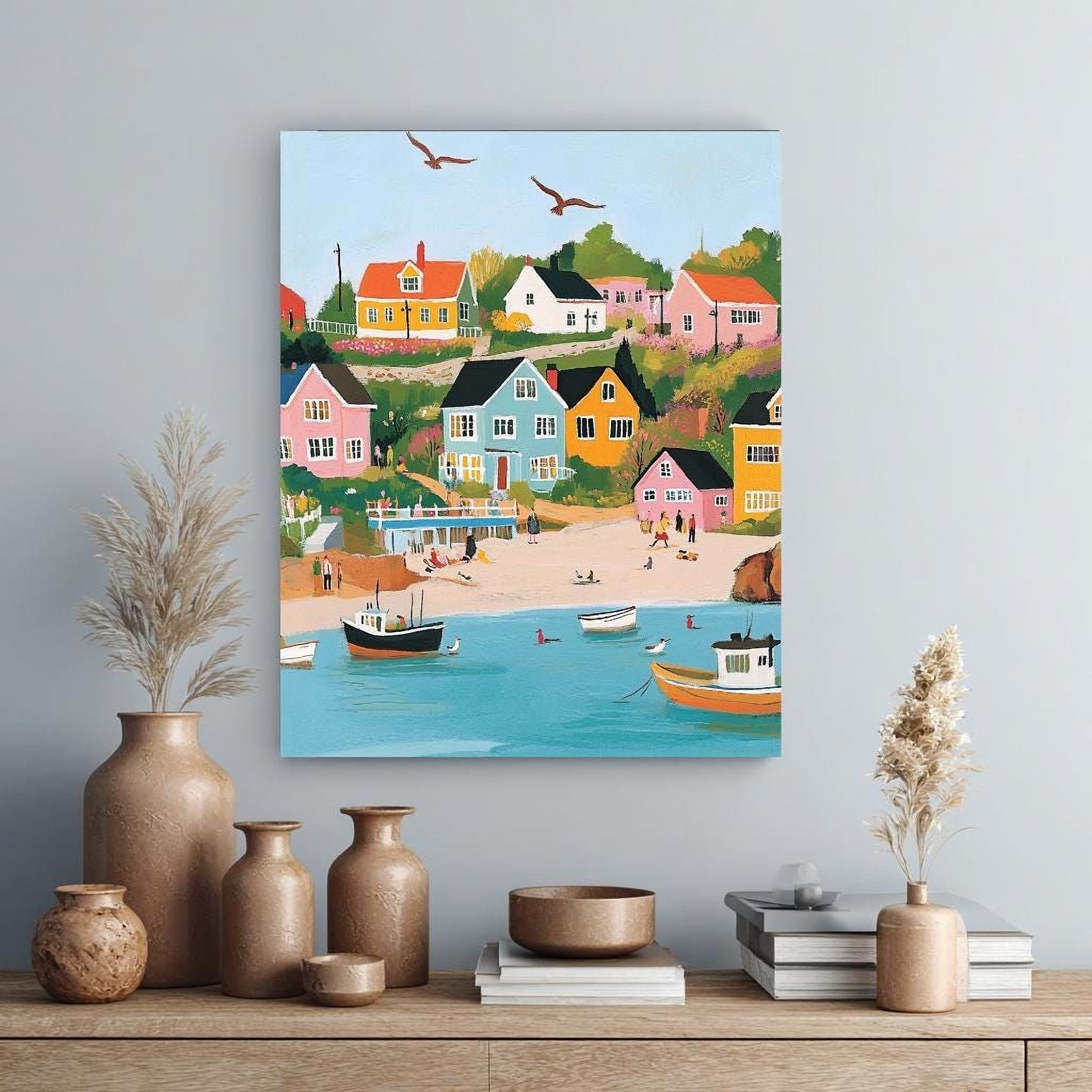 a vibrant painting of a coastal town with colorful houses, boats, and people on the beach. The painting is hung on a wall above a wooden shelf with various decorative items, including vases and books.