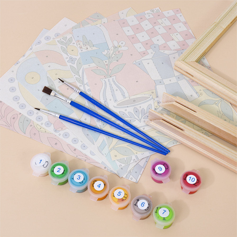 various art supplies, including paintbrushes, paint tubes, and pattern pieces, arranged on a table.