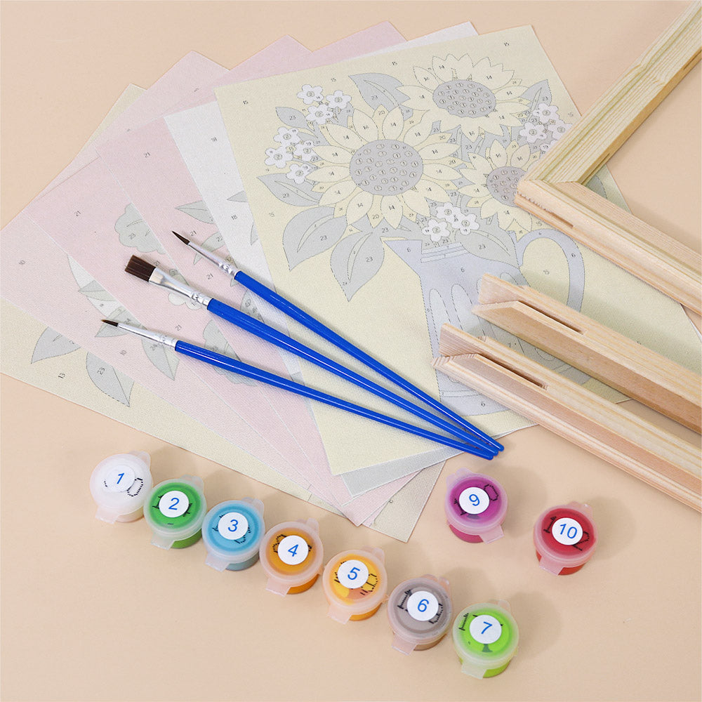various art supplies, including paintbrushes, watercolor paints, and a canvas with a floral pattern.