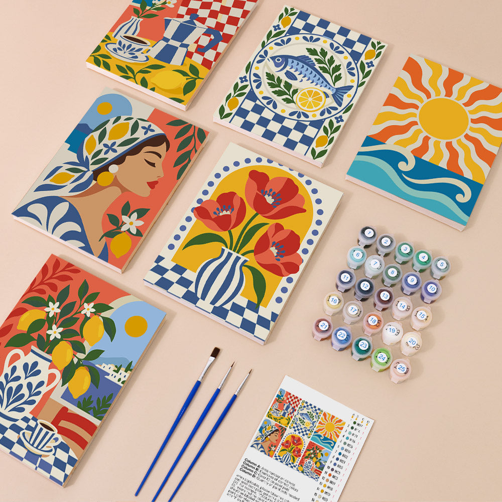 a collection of colorful paintings, art supplies, and a guidebook for painting, arranged on a light-colored surface.