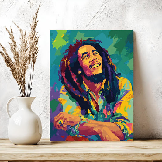 a colorful painting of a smiling man with dreadlocks, displayed on a wooden surface next to a white vase with dried flowers.