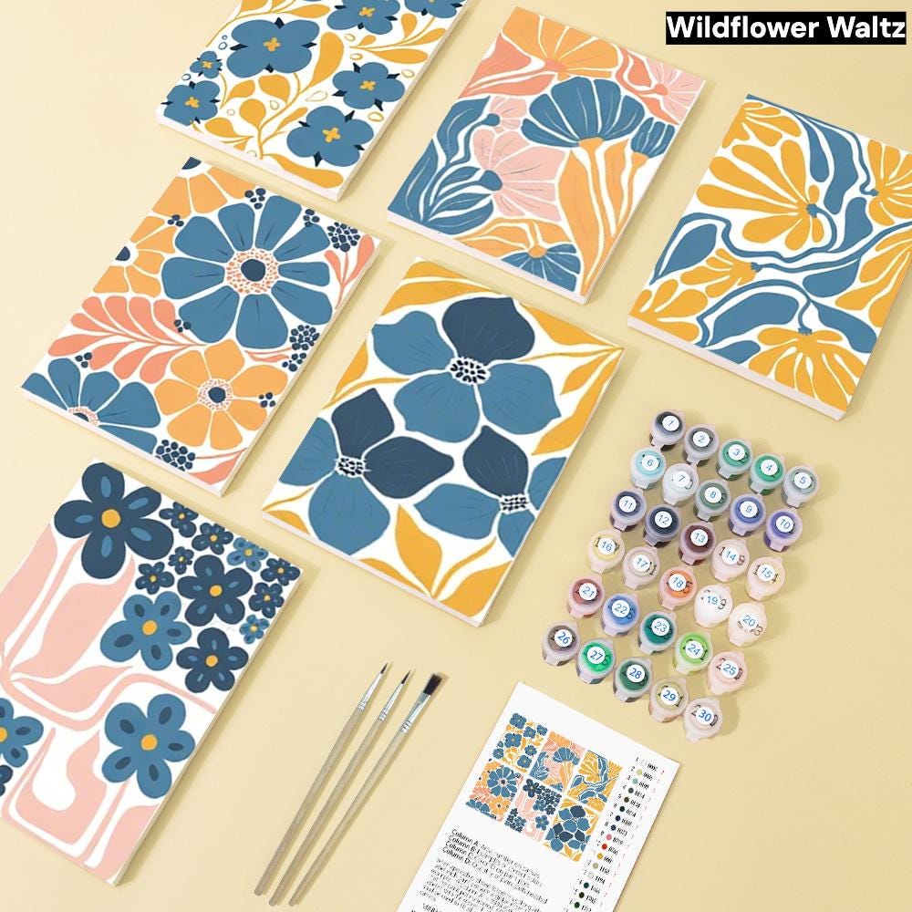 a collection of six notebooks with various floral and nature-inspired designs, along with paintbrushes and paint tubes, suggesting an art or craft project.