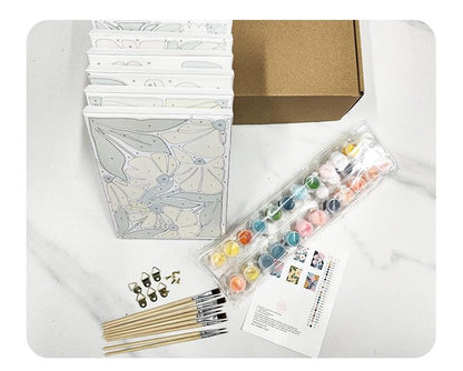 a variety of art supplies, including a box of paints, brushes, and a set of watercolor paints, arranged on a marble surface.
